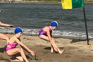 youth racing on beach for lifesaving competition
