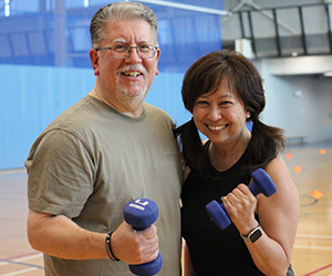 July member profile photo, adult couple holding weights