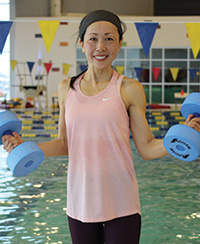 Female aquafit instructor holding dumbbells
